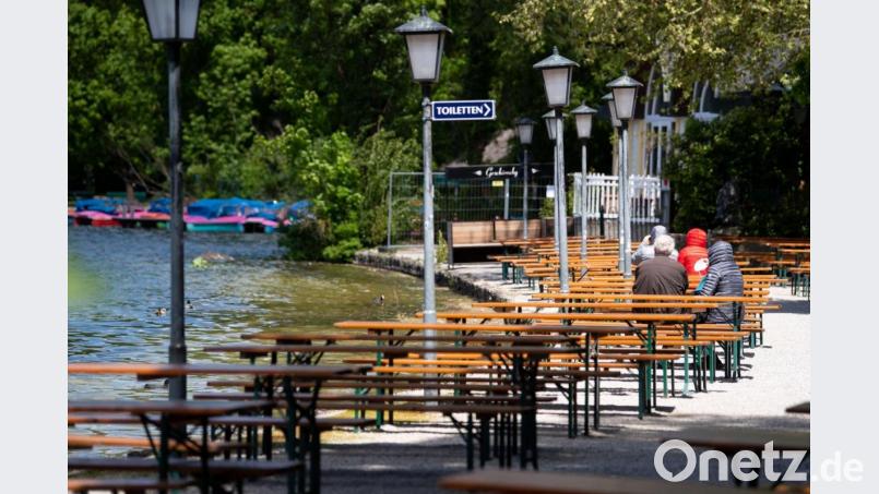 Nur wenige Gäste sitzen im englischen Garten am Kleinhesseloher See in einem Biergarten. Symbolbild: Sven Hoppe/dpa