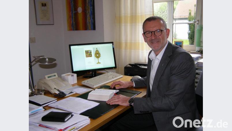 Stadtpfarrer Thomas Vogl in seinem Arbeitszimmer im Pfarrbüro. Auf dem Bildschirm ist die Ansicht der Grußkarte mit der Monstranz als Motiv auf dem Titel zu sehen. Bild: pz