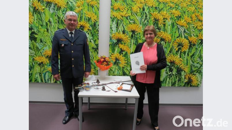 Erster Polizeihauptkommissar Werner Schönfelder verabschiedete Polizeiangestellte Jutta Bork nach 46 Jahren Dienstzeit mit einem Präsent in den Ruhestand. Bild: Polizeiinspektion Tirschenreuth/exb