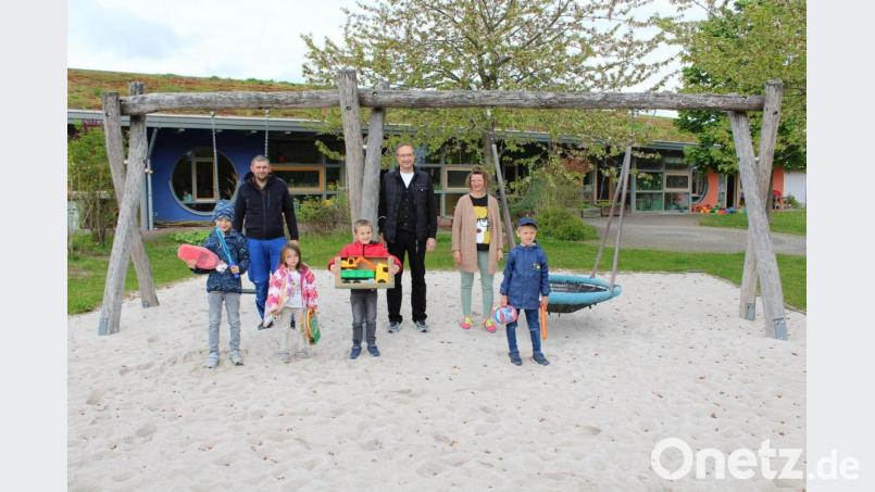 Preisverleihung auf 200 Tonnen Sand (von links): Thomas Schön (Hausmeisterei), die Vorsitzende Regina Singer-Mindt und Kassier Jürgen Schröther vom Elternbeirat des Kindergartens sowie vier glückliche Gewinner. Bild: Theresa Ehbauer