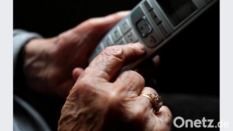 Eine ältere Frau tippt auf einem schnurlosen Festnetztelefon. Symbolbild: Karl-Josef Hildenbrand/dpa