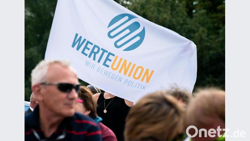 Eine Anhängerin der Werteunion steht mit einer Fahne bei einer Veranstaltung. Symbolbild: Michael Kappeler