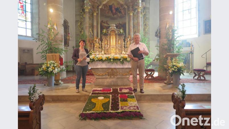 Katharina Lippert (links) spielte mit ihrer Querflöte erstmals bei einem Gottesdienst in der Stadtpfarrkirche. Nicht nur sie und Josef Zaglmann (rechts) bewunderten den prächtigen Blumenteppich des Pfarrgemeinderates. Bild: jzk