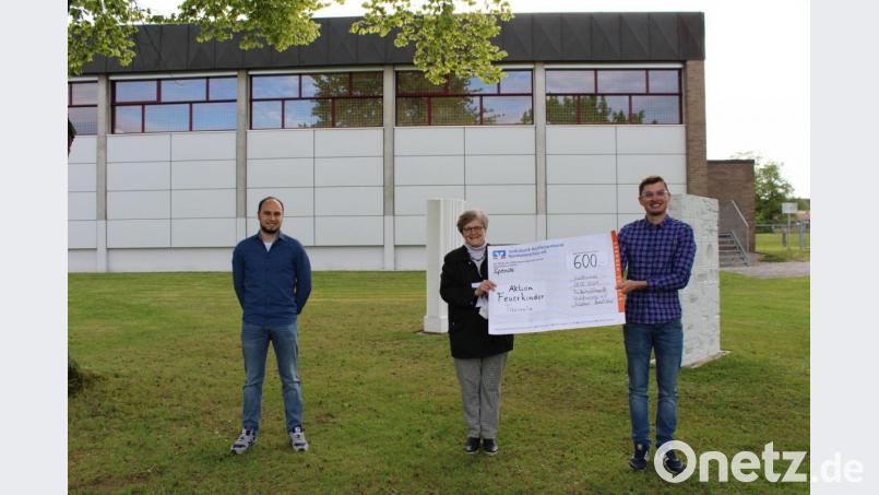 Die Übergabe des symbolischen Schecks an Dr. Annemarie Schraml für ihre &quot;Feuerkinder&quot;-Organisation durch Vorsitzendem Max Siller (rechts) und Manuel Ernst. Bild: Federballfreunde/exb