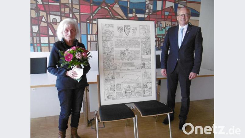 Mit einem Blumenstrauß dankte Bürgermeister Bernhrad Lindner der Künstlerin Elisabeht Künzl für das Jubiläumsbild, das sie dem Markt Hahnbach zu dessen Jubiläum geschenkt hat. Bild: mma