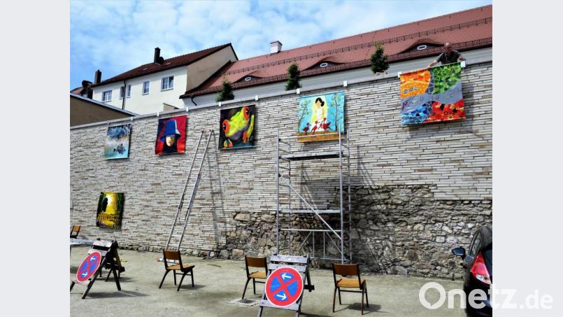 Kunst trifft Denkmal: Am Montagmorgen kümmerten sich Hochbautechniker Lutz Zangl sowie Hans Enslein und Christoph Kick vom MQ um die Installation der großformatigen Bilder an der Mauer. Bild: ubb