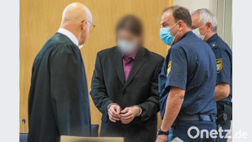 Der damals Angeklagte (Zweiter von links) steht am 1. Juli 2020 mit Mundschutz im Verhandlungssaal des Landgerichts neben Polizisten und seinem Verteidiger Michael Haizmann (links). Archivbild: Armin Weigel