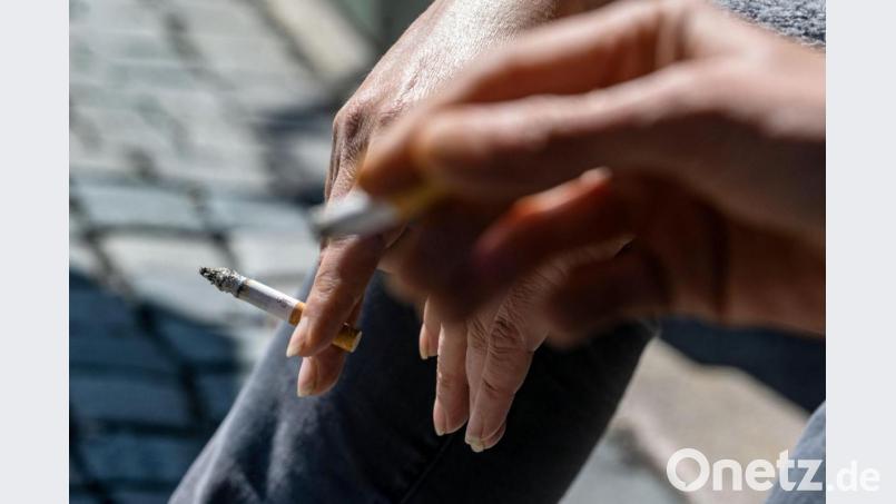 Raucher halten eine brennende Zigarette in der Hand. Bild: Armin Weigel/dpa