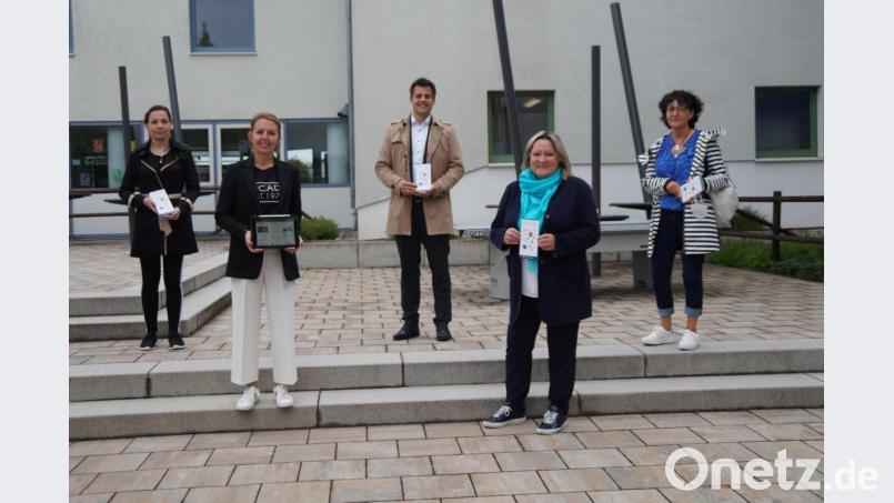 Rektorin Christine Schneider (Zweite von rechts) überreicht den Flyer mit dem von Konrektorin Stefanie Hauser (Zweite von links) entwickelten Konzept für die Offene Ganztagsschule an (hinten, von links) Margit Boch (Stadtmarketing), Bürgermeister Rudolf Teplitzky und Fördervereins-Vertreterin Lydia Eckert. Bild: wel