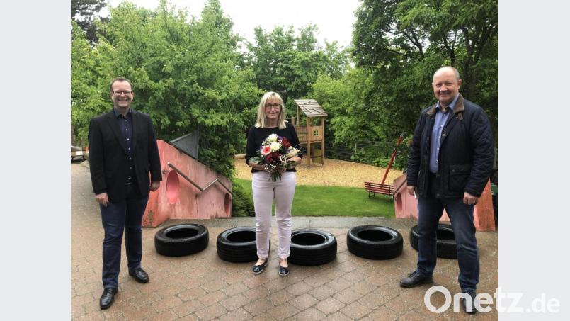 Stadtpfarrer von St. Martin, Thomas Helm (links) und Peter Kehl von der Kirchenverwaltung (rechts) gratulierten der Leiterin des Kindergartens St. Martin, Annett Rodehau (Mitte), zu ihrem 25-jährigen Dienstjubiläum. Bild: ads