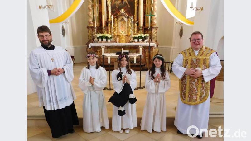 Eva Horn (Plössen), Violetta Veigl (Ramlesreuth) und Alina Walter (Lämmershof, von links) feierten am Sonntag feierlich ihre erste Heilige Kommunion. Mit Ihnen freuten sich Pfarrer Sven Grillmeier (rechts) und Pastoralreferent Robert Schultes. Bild: hai