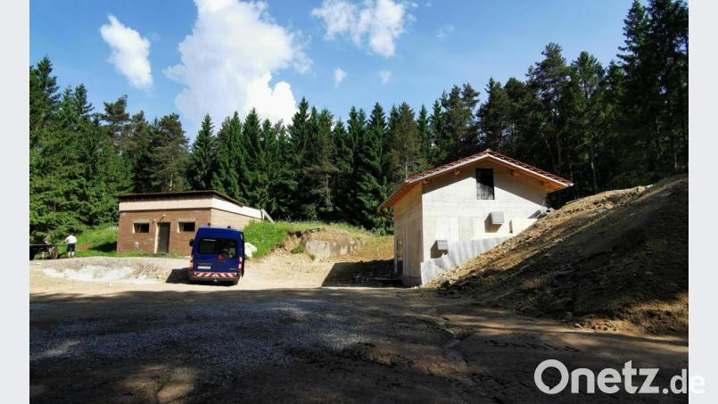 Bald ist es vorbei, mit den zwei Häuschen im Oberviechtacher Hochwald: Nachdem der neue Hochbehälter Roßhaupt (rechts) angeschlossen ist, startet jetzt der Rückbau des alten Technikgebäudes (links) samt Stahlbetonkammern (Mitte). Danach wird das Gelände eingeebnet und Magerrasen angesät. Bild: Portner