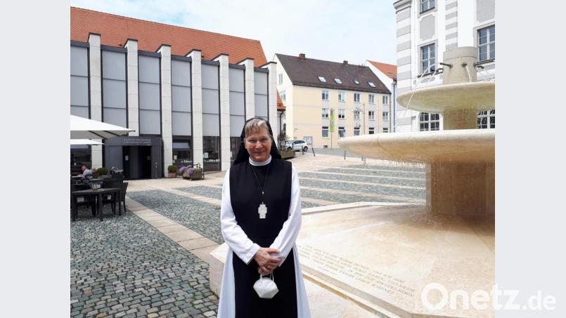 Äbtissin Laetitia Fech beim Brunnen im Pfortenhof des Klosters Waldsassen, im Hintergrund links das klösterliche Gästehaus St. Joseph. Bild: pz