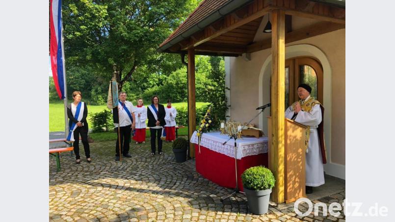 Vor der Reuther Kapelle zelebrierte Pfarrer Heribert Stretz (rechts) den Dankgottesdienst, zu dem auch eine Abordnung des örtlichen Radfahrervereins Concordia mit der Fahne Aufstellung genommen hat. Bild: jzk