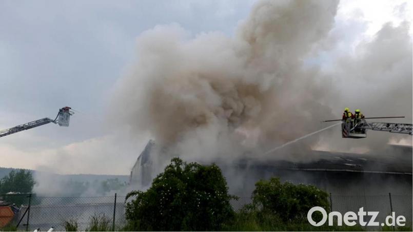 Die Feuerwehren gingen mit zwei Drehleitern gegen die Flammen in der Lagerhalle eines Entsorgungsbetriebs in Burglengenfeld vor. Bild: slh/exb