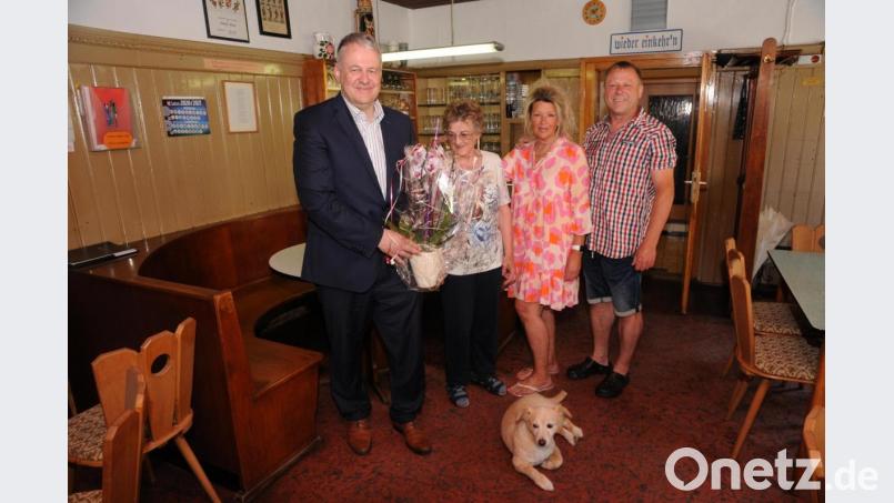Wirtin Lore (Zweite von links) freut sich über die Orchidee von Landrat Richard Reisinger; Tochter Claudia, Schwiegersohn Jürgen sowie Wirtshaushund Dzino freuen sich mit - selbstverständlich alle getestet und geimpft. Bild: ige