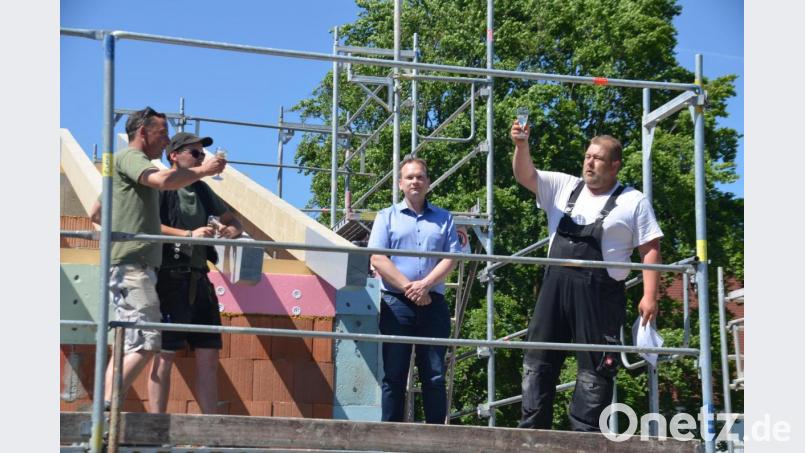 Maurerpolier Oliver Götte, Zimmerer Timo Fürbringer, Bürgermeister Christian Porsch und Zimmererpolier Thomas Schnürrer stoßen auf den Erweiterungsbau des Kindergartens an. Bild: ak