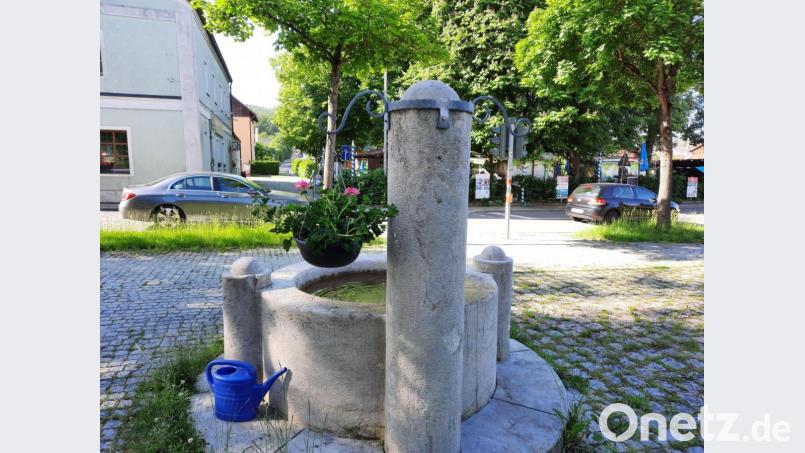 Blumen-Kriminalfall in Raigering: Am Brunnen in Raigering hat jemand eine von Ehrenamtlichen liebevoll gepflegte Blumenschale gestohlen. Das Gegenstück der Pflanzenschale auf der rechten Seite fehlt deshalb. Bild: Gerda Eiber/exb