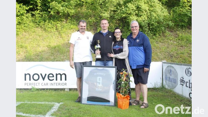 Mit einem Gutschein für den scheidenden Trainer und einem Blumenstock für seine Frau Melanie bedanken sich Vorsitzender Hans Wiesnet (links) und Spartenleiter Gerhard Wilterius (rechts) „für sieben tolle Jahre“. Von der Mannschaft gibt zum Abschied ein eingerahmtes Trikot mit seiner Rückennummer 9 sowie ein Bild mit dem Großteil der Spieler, die in den letzten sieben Jahren bei ihm zum Einsatz kamen. Bild: wmi