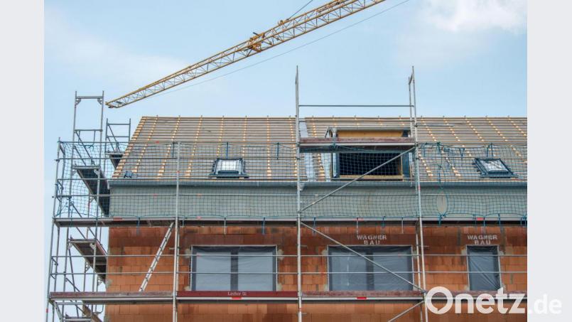 Ein Baukran streckt sich über den den Rohbau eins Wohnhauses. Der Oberviechtacher Bauausschuss hat einige Anträge für verschiedene Bauvorhaben genehmigt. Symbolbild: Lino Mergeler/dpa
