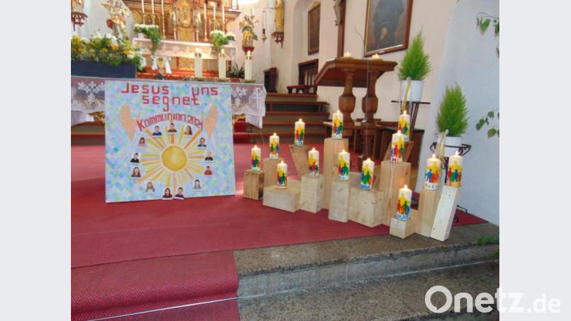 Die Erstkommunionkinder brachten ihre selbst gestalteten Tischkerzen mit. Diese schmückten während des Gottesdienstes den Altarraum. Bild: rpp