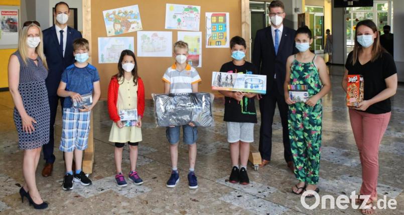 Die Gewinner des Malwettbewerbs (erste Reihe ab zweiten von links) Toni Böckl, Hira Kaya, Timo Wagner, Lika Jannik und Olivia Jackson. Mit auf dem Bild (von links) Rektorin Sabine Graser, die beiden Bankvertreter Victor Hofmann und Alexander Goblisch sowie Lehrerin Kristina Grünauer, den den Preis von Charlotte Berg in Händen hält. Bild: njn