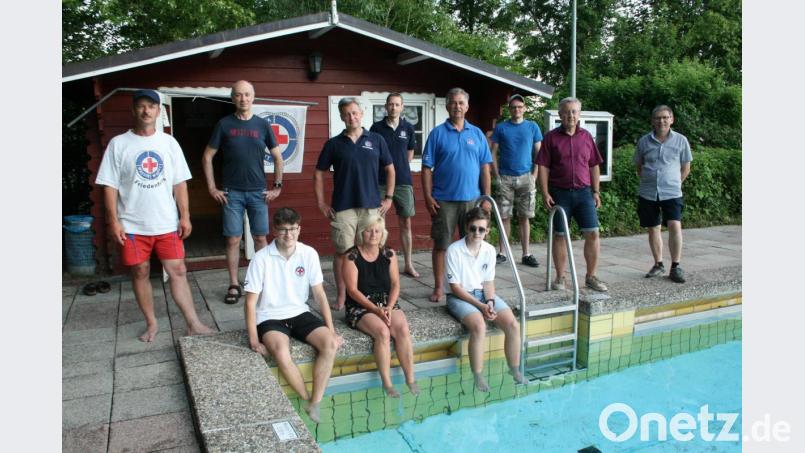Das neugewählte Vorstandsteam der Wasserwacht mit Vorsitzendem Markus Münchmeier (stehend, Dritter von links) am Schwimmbecken. Bild: roh