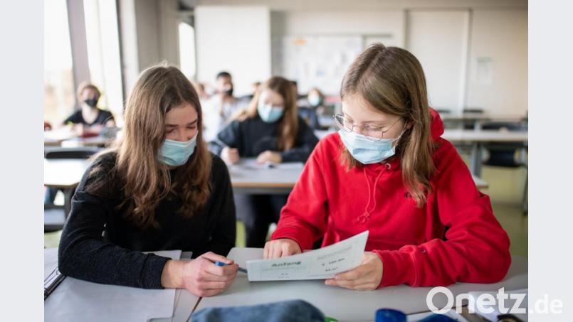 Zwei Schülerinnen mit Mund- und Nasenschutz beraten sich im Unterricht in einem Geographie-Seminar in der Jahrgangsstufe elf am staatlichen Gymnasium Trudering über ein Arbeitsblatt. Bild: Matthias Balk