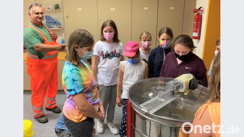 Imkerpate Josef Sellner (links) beobachtet die Schüler aus der Bienen-AG beim Honigschleudern und gibt gute Tipps. Bild: no