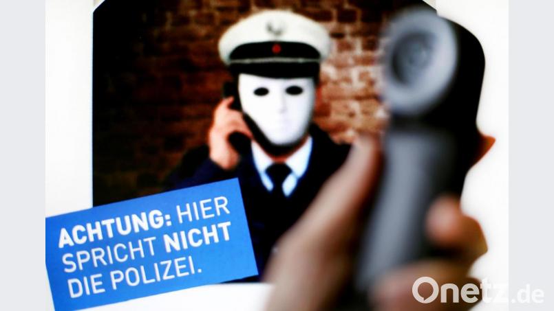 Ein Telefonhörer vor einem Plakat der Polizei mit der Aufschrift „Achtung: Hier spricht nicht die Polizei“: Bild: dpa