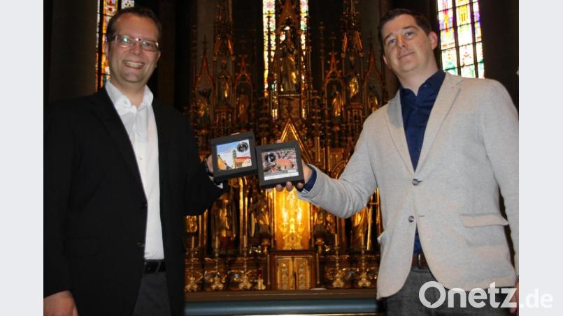 Stadtpfarrer Thomas Helm (links) freute sich über die ersten beiden Gedenkmünzen aus der limitierten Auflage der Sonderprägung zur Würdigung der Martinskirche im Jubiläumsjahr, die ihm der Prokurist der Münz-Gesellschaft „Euro Mint“, Lars Knevels (rechts), überreichte. Bild: ads