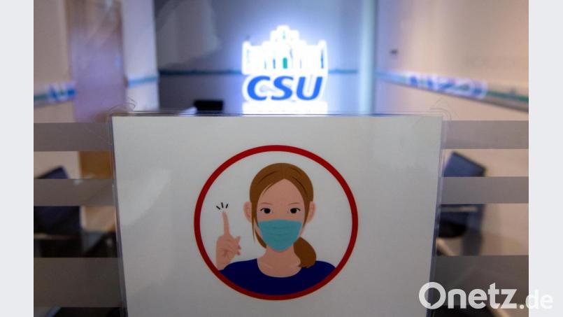 Ein Maskenpflicht-Schild vor CSU-Lampe: Der Vorstand der CSU-Landtagsfraktion beschloss strengere Regeln für Nebeneinkünfte.. Bild: Sven Hoppe