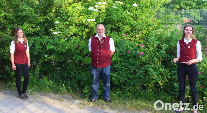 Chefdirigent Gerhard Böller (Mitte) überreicht den Dirigentenstab an Veronika Kick (links) und Tamara Lindner (rechts) und wünschte ihnen viel Erfolg bei der Leitung des Gebenbacher Nachwuchsorchesters. Bild: swo