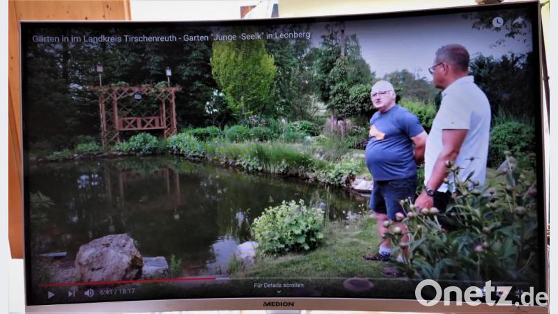 Manfred Junge hat vor vielen Jahren einen großen Gartenteich angelegt. Inzwischen schwimmen seine acht Enkel im Teich und mit ihnen die Frösche. Das gefällt Gartenfachberater Harald Schlöger (rechts). Screenshot: ubb