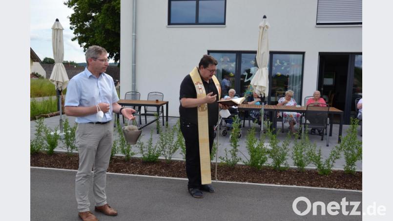 Pfarrer Udo Klösel segnete das neue Haus der „Wohnanlage und Tagespflege an der Wieskirche" in Moosbach“. Der frühere Bürgermeister und jetzige Gemeinderat Hermann Ach assistiert dazu als Ministrant. Ach gilt als Initiator des Gebäudebaues in den Jahren 2019/2020. Bild: gi