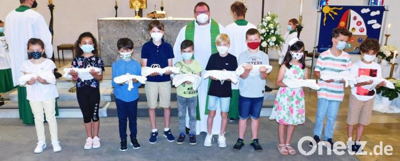 Maresa Jehring, Swamy Longo, Ben Kottwitz, Fabian Busch, Emanuele Saponaro, Jonah Micklisch, Niklas Prechtl, Jasmin Selmi, Maik-Leon Schmidt und Aven Paez (von links) erhalten in der Dreifaltigkeitskirche in diesem Jahr erstmals aus den Händen von Pfarrer Sven Grillmeier (Mitte) die Heilige Kommunion. Bild: hai