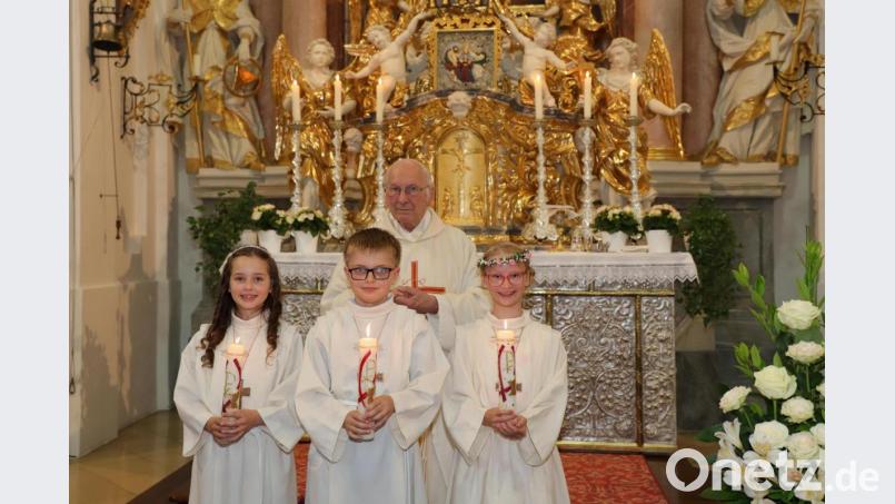 Nach der Erstkommunion in der Kapplkirche, von links Lara Laab, Michael Eckert, Laura Dostler mit Pater Friedhelm Czinczoll. Bild: Pfarrei Münchenreuth/exb