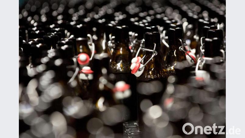 Bierflaschen mit Bügelverschluss laufen in der Abfüllhalle einer Brauerei zur Abfüllstation. Archivbild: Christian Charisius/dpa