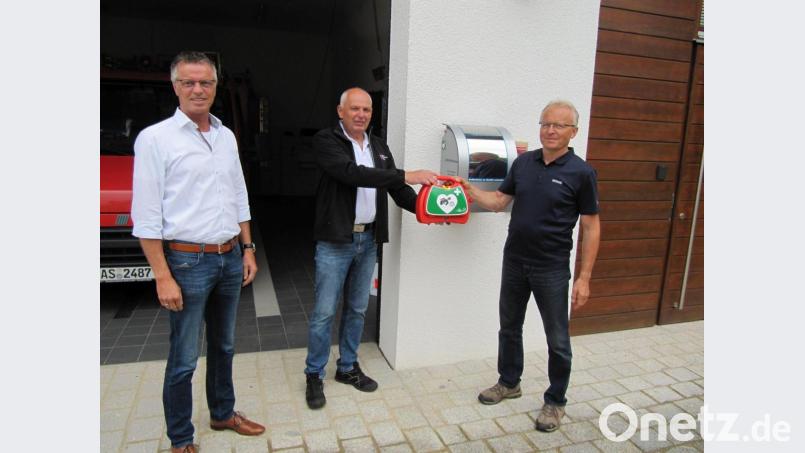 Den Defi in Steiningloh nehmen Bürgermeister Hermann Falk, BRK-Rettungsdienstleiter Erwin Gräml und Feuerwehrkommandant Ludwig Fischer offiziell in Betrieb. Bild: fg