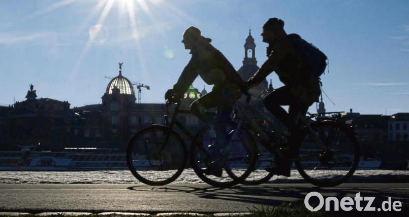 Radfahrer auf dem Elberadweg am Königsufer gegenüber der Dresdner Altstadt mit der Kuppel der Kunstakademie (links) und der Frauenkirche. Archivbild: Robert Michael/dpa