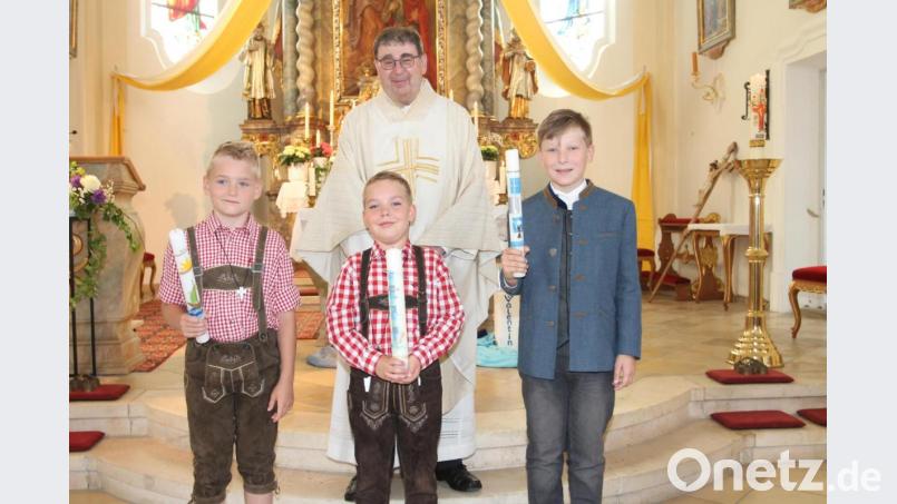 Stadtpfarrer Pater Hans Ring feiert mit drei Jungen Erstkommunion. Bild: pi