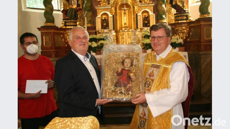 Kirchenpfleger Hilmar Wollner (Zweiter von links) übergab im Namen aller kirchlichen Verbände und Vereine eine Jesusfigur in der Krippe an Stadtpfarrer Bernd Philipp (rechts). Bild: fpoz