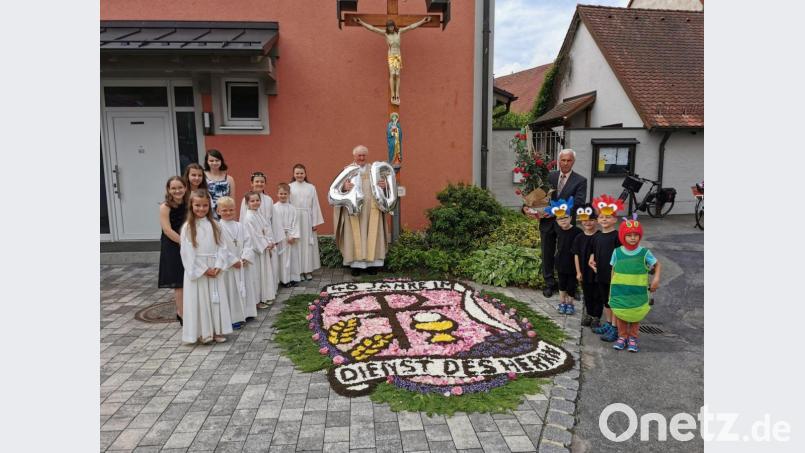 Am Jubeltag überraschte Frauenbund Pfarrer Erwin Bauer mit einem herrlichen Blumenteppich. Kinder gratulierten in Versform und mit Geschenken. Bild: gz