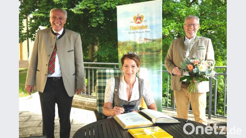 Die Bayerische Bierkönigin Sarah Jäger trägt sich ins Goldene Buch der Stadt Schwandorf ein. Sehr zur Freude von Oberbürgermeister Andreas Feller (rechts) und Brauereibesitzer Wolfgang Rasel (links), die zur Wahl gratulierten. Bild: Hirsch