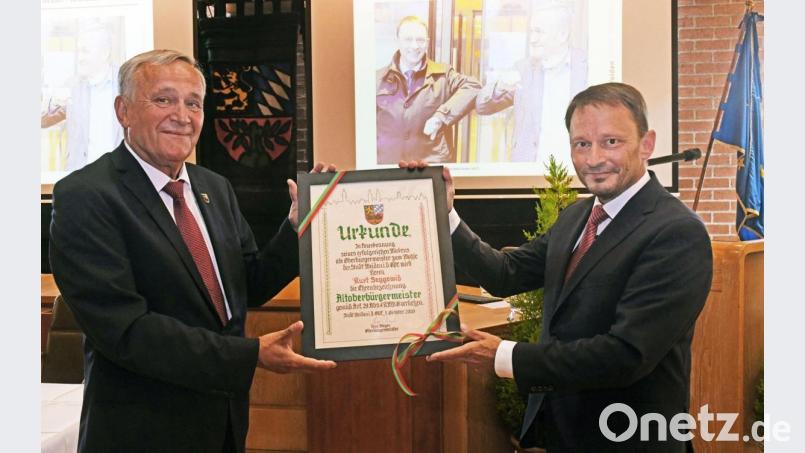Die Urkunde bestätigtes es schwarz, grün und rot auf weiß: Kurt Seggewiß (links) ist nun Altoberbürgermeister von Weiden. Der aktuelle Oberbürgermeister Jens Meyer gratuliert. Bild: Gabi Schönberger
