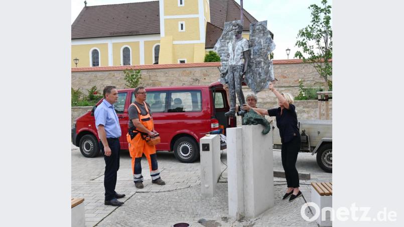 Hanna Regina Uber und Robert Diem (von rechts) sichern den Erzengel Michael mit Mehrfahrkomponentenkleber auf seinem Sockel und justieren die Bronzefigur einige Male nach, damit der für die nächsten Jahrzehnte dort auch sicher steht. Bürgermeister Hermann Böhm (links) wollte trotz der fehlenden Sitzbänke mit dem Aufstellen des Erzengels nicht länger warten. Bild: gf