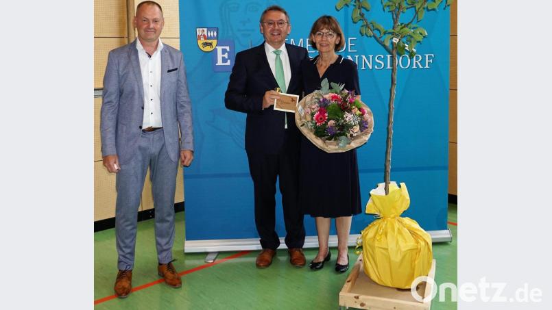 Bürgermeister Erich Meidinger (links) überreicht bei der offiziellen Verabschiedung an Josef Gilch und Conny Gilch einen Birnbaum namens Conference und einen Reisegutschein. Bild: wec