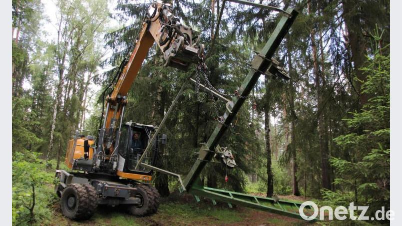 Mit einem Bagger transportiert Jens Stich ein aus dem Boden gelöstes Metallgestell des Skilifts ab. Bild: kro