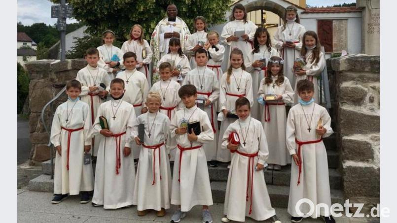 21 Kinder feiern in der Pfarrei Wutschdorf mit Pfarrer Moses Gudapati (hinten, links) Erstkommunion. Bild: gri