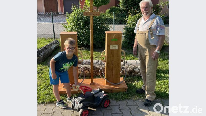 Ben betankt stolz sein Bobby Car an der Tankstelle, die sein Opa Eduard Ströhl für den Kindergarten gebaut hat. Bild: Kindergarten St. Vitus/exb